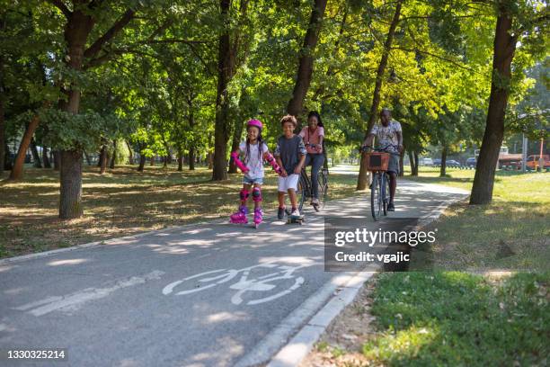 family sports day - mother and daughter riding on skateboard in park stock pictures, royalty-free photos & images