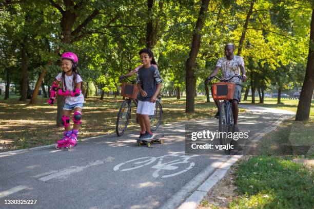 family sports day - mother and daughter riding on skateboard in park stock pictures, royalty-free photos & images