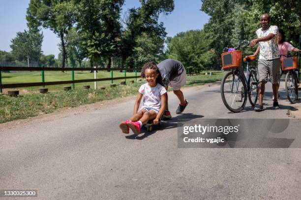 brother and sister have fun with skateboard - mother and daughter riding on skateboard in park stock pictures, royalty-free photos & images