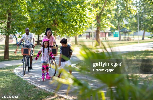 weekend with family - mother and daughter riding on skateboard in park stock pictures, royalty-free photos & images