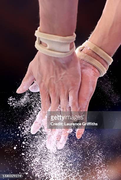 Detail of an athlete chalking their hands during Men's Qualification on day one of the Tokyo 2020 Olympic Games at Ariake Gymnastics Centre on July...