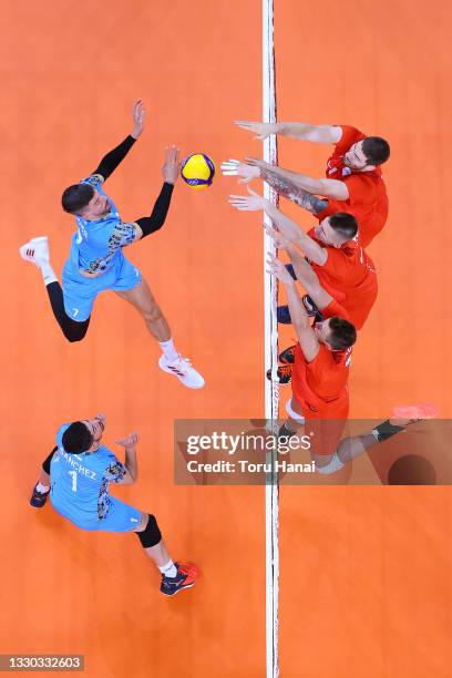 Facundo Conte of Team Argentina battles at the net with the Team ROC defense during the Men's Preliminary Round - Pool B on day one of the Tokyo 2020...