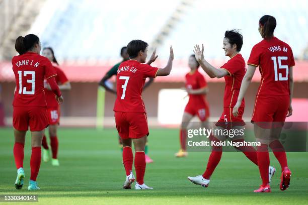 Shuang Wang of Team China celebrates with team mates after scoring their side's first goal during the Women's First Round Group F match between China...