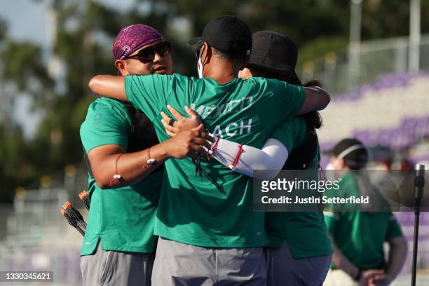 Luis Alvarez and Alejandra Valencia of Team Mexico celebrate with their coach after winning the bronze medal for the Mixed Team competition on day...