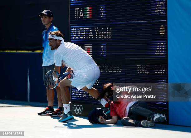 Fabio Fognini of Team Italy collides with a line judge during his Men's Singles First Round match against Yuichi Sugita of Team Japan on day one of...