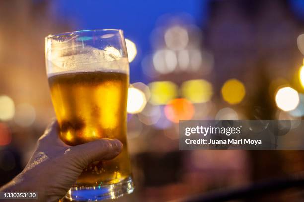 half liter glass of beer, in the background blur of night city lights. in wroclaw. poland - bier dunkel stock-fotos und bilder