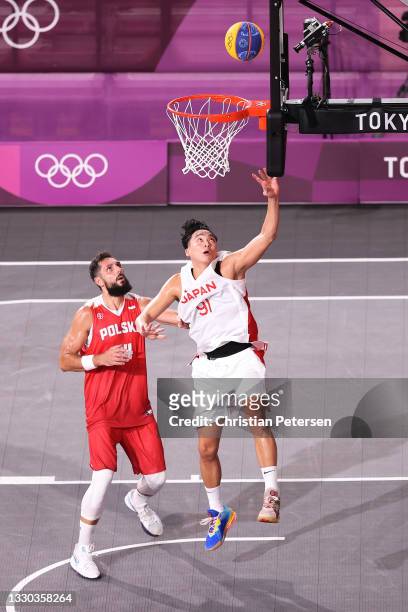 Tomoya Ochiai of Team Japan drives to the basket under pressure from Pawel Pawlowski of Team Poland during the Men's Pool Round match between Japan...