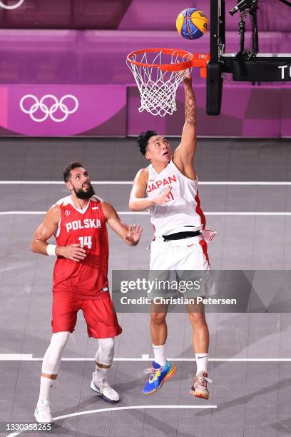 Tomoya Ochiai of Team Japan drives to the basket under pressure from Pawel Pawlowski of Team Poland during the Men's Pool Round match between Japan...