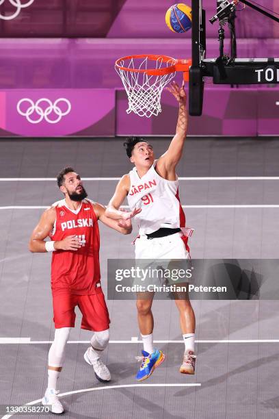 Tomoya Ochiai of Team Japan drives to the basket under pressure from Pawel Pawlowski of Team Poland during the Men's Pool Round match between Japan...