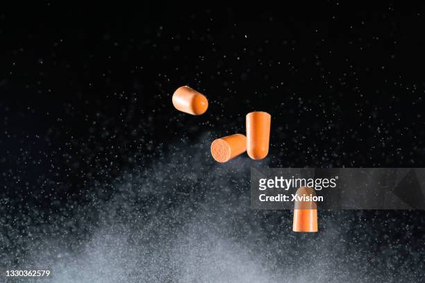 sound insulation earplugs flying in mid air captured with high speed sync. - small concert stock pictures, royalty-free photos & images
