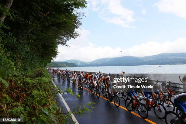 The peloton passes through Lake Ashi on Kagosaka Pass during the Men's road race at the Fuji International Speedway on day one of the Tokyo 2020...