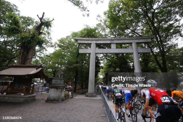 Michael Schar of Team Switzerland and the peloton passes through Okunitama Shrine during the Men's road race on day one of the Tokyo 2020 Olympic...