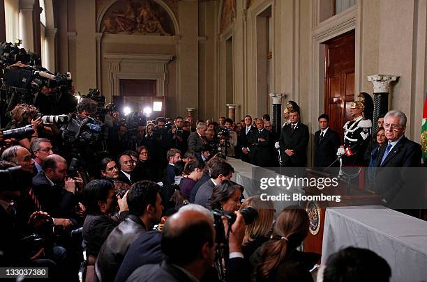 Mario Monti, Italy's prime minister designate, right, pauses during a news conference to announce the names of the cabinet ministers that will form...