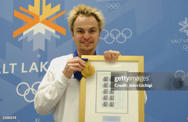 Steven Bradbury, one of Australia's two gold medalists, poses with his commemorative stamps and gold medal during the Australian Press Conference at...