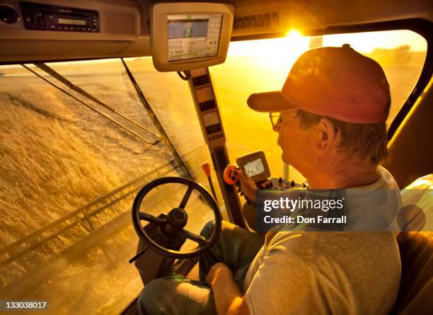 farmer in combine cab, farming equipment. - newoutdoors stock pictures, royalty-free photos & images