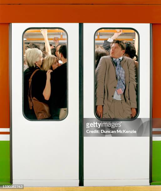crowded passenger train at rush hour - clothing too small stock pictures, royalty-free photos & images