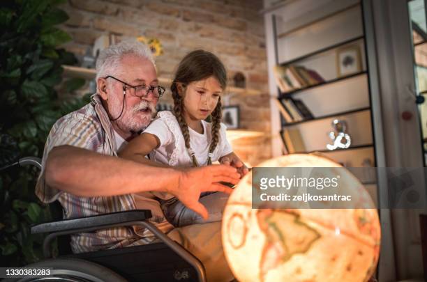 Grandfather and grandchild are smiling while playing with toys together at home