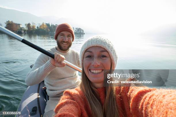 young couple taking selfie portrait in canoe on mountain lake - using a paddle stock pictures, royalty-free photos & images