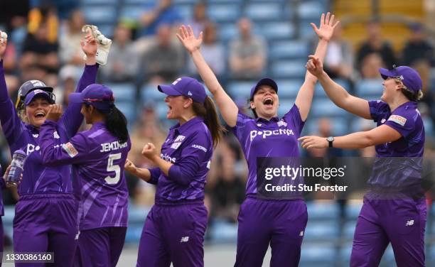 Superchargers fielder Alice Davidson-Richards celebrates with team mates after Sophie Luff is given out after review during The Hundred match between...