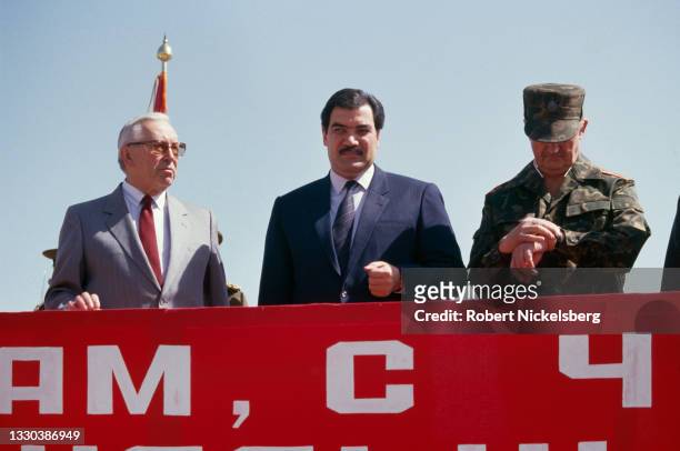 Flanked by unidentified Soviet officials, Afghan President Mohammad Najibullah attends the formal ceremony of the Soviet army withdrawal, Kabul,...