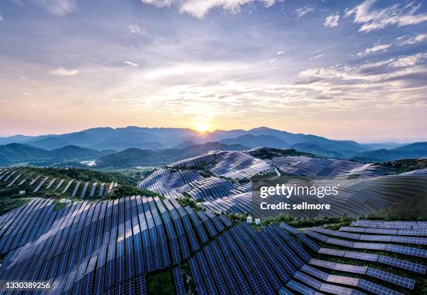 drone point of view at the solar power station on the top of the mountain at sunset - zonnecellen stockfoto's en -beelden