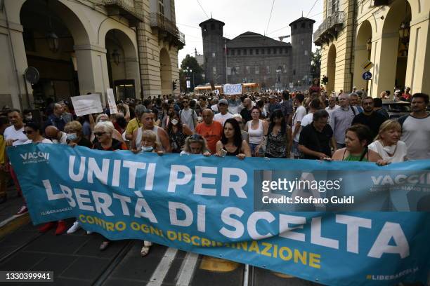 Demonstrators carry a large sign during the Green Pass Protest on July 24, 2021 in Turin, Italy. The health pass, "Green Pass", will be mandatory...