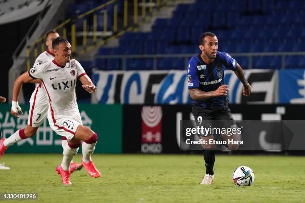 Leandro Pereira of Gamba Osaka in action under pressure from Diego Pituca of Kashima Antlers during the J.League Meiji Yasuda J1 match between Gamba...