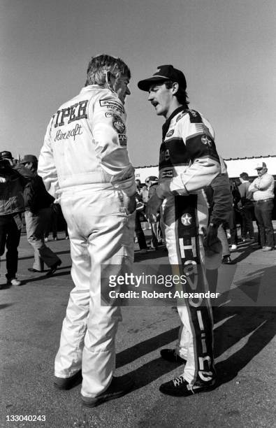Driver Bobby Allison, left, talks with his son, fellow race driver Davey Allison, in the Daytona International Speedway garage prior to the 1988...