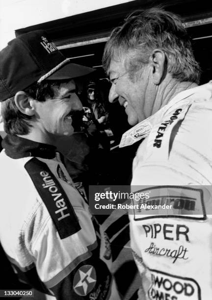 Driver Bobby Allison, left, talks with his son, fellow race driver Davey Allison, in the Daytona International Speedway garage prior to the 1988...