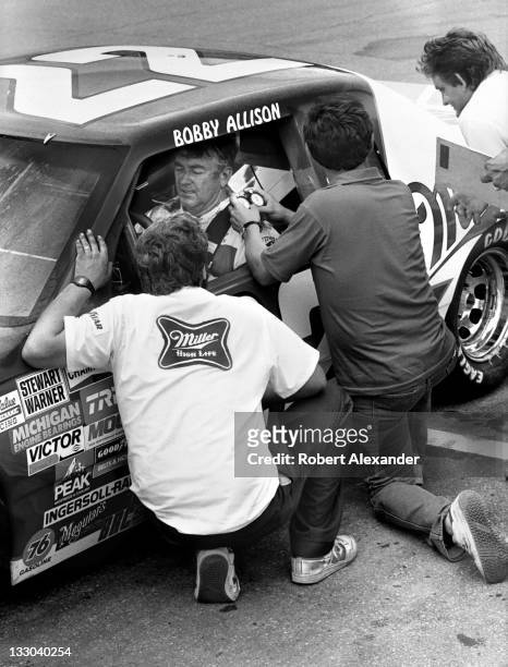 Driver Bobby Allison talks with his crew members during a practice session for the 1985 Firecracker 400 on July 3, 1985 at the Daytona International...