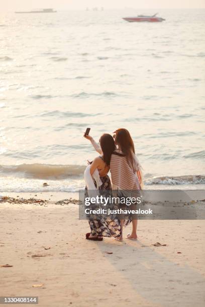 chinese tourist women are taking a selfie together on beach in pattaya - pattaya stock pictures, royalty-free photos & images