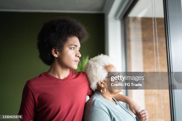 grandmother and grandson contemplating at home - family with teenagers stockfoto's en -beelden