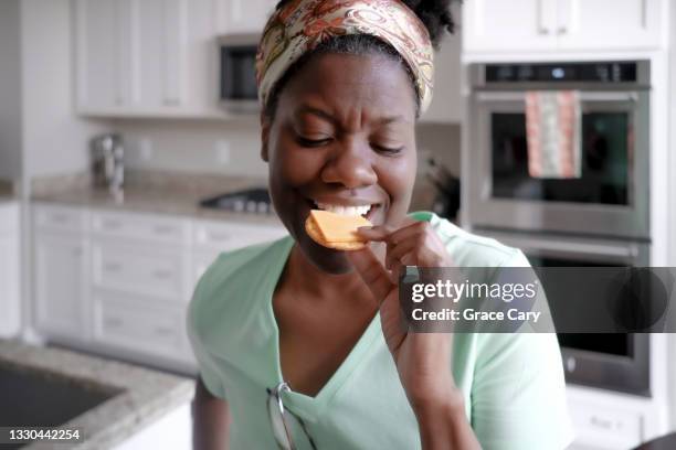 woman snacks on crackers and cheese - salzige zwischenmahlzeit stock-fotos und bilder