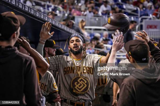 Fernando Tatis Jr. #23 of the San Diego Padres celebrates with teammates in the dugout after hitting a solo homerun in the first inning against the...