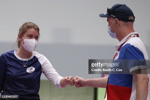 Gold Medalist and Olympic Record holder Vitalina Batsarashkina of Team ROC celebrates with her coach following the 10m Air Pistol Women's event on...