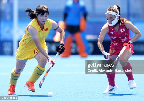 Jinrong Zhang of Team China moves the ball past Hazuki Nagai of Team Japan during the Women's Pool B Match on day two of the Tokyo 2020 Olympic Games...