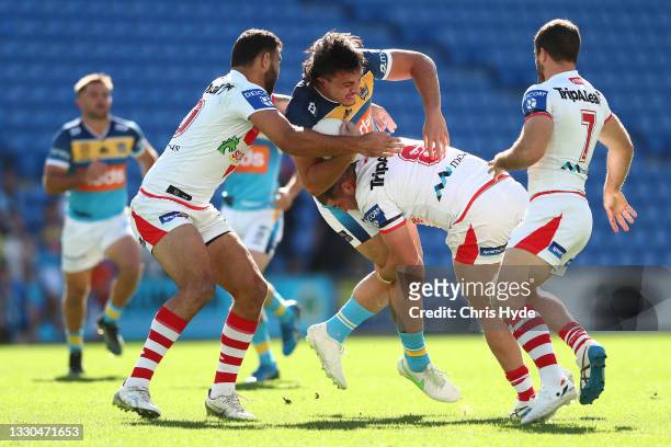 Tino Fa'asuamaleaui of the Titans is tackled during the round 19 NRL match between the St George Illawarra Dragons and the Gold Coast Titans at Cbus...
