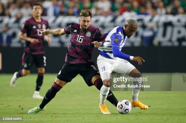 Hector Herrera of Mexico grabs the jersey of Deybi Flores of Honduras as they battle for contrl of the ball during the first half of the Concacaf...