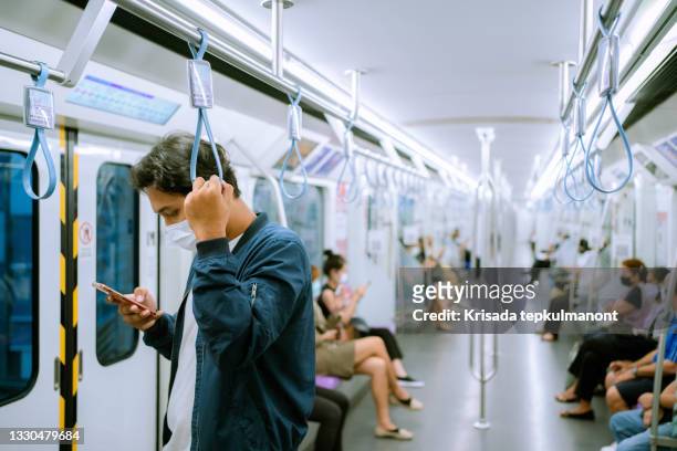 businessman using mobile phone on public train. - covid commuter stock pictures, royalty-free photos & images