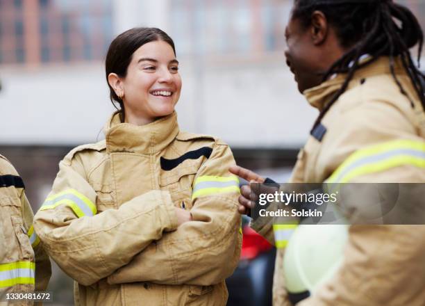 firefighters standing together, laughing - wachsamkeit stock-fotos und bilder
