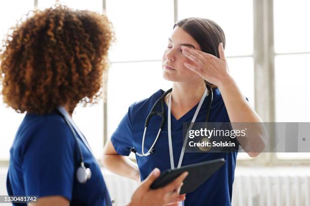 two healthcare professionals in conversation - tired healthcare worker stock pictures, royalty-free photos & images