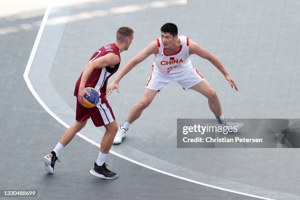 Jinqiu Hu of Team China defends on Karlis Lasmanis of Team Latvia during the Men's Pool Round match between China and Latvia on day two of the Tokyo...