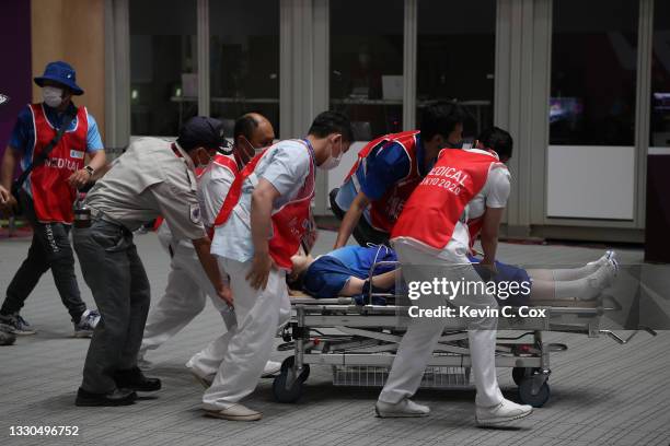 Volunteer collapses during the medal ceremony for the 10m Air Rifle Men's event event on day two of the Tokyo 2020 Olympic Games at Asaka Shooting...