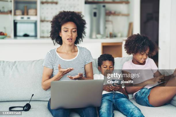 african-american mother working at home - mother and son using tablet and laptop stock pictures, royalty-free photos & images