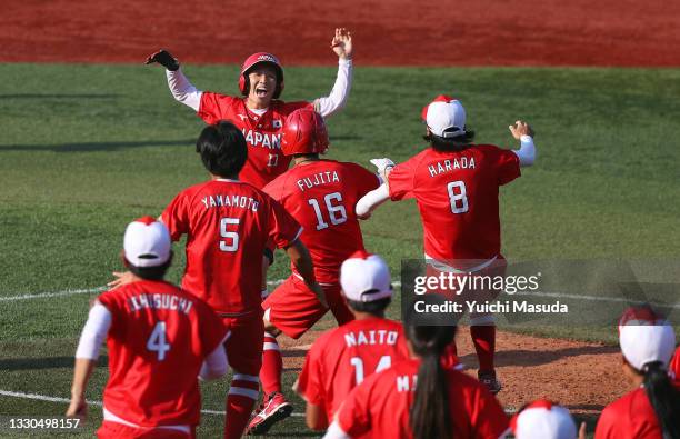 Eri Yamada of Team Japan celebrates her game-winning RBI against Team Canada in the eighth inning with her teammates during the Softball Opening...