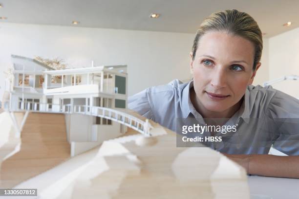 female architect examining architectural model - architekturmodell stock-fotos und bilder