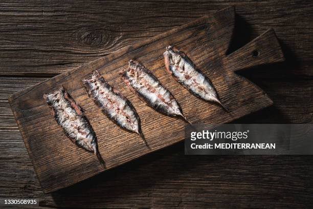 anchois anchois sel de poisson cru mariné sur une planche à découper en bois - marine photos et images de collection