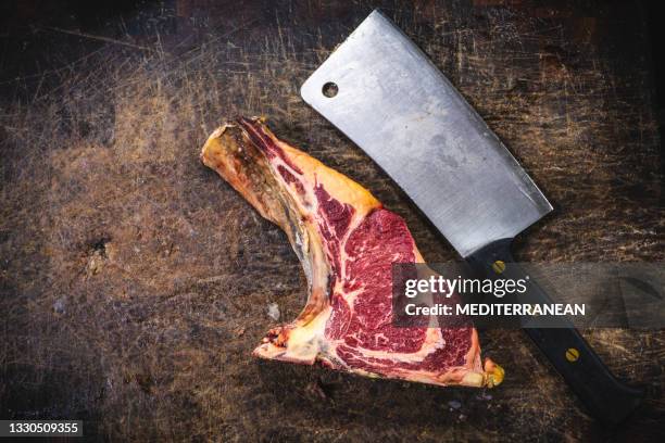 cuchilla de carne de carnicero y filete de carne de ternera añejado en seco sobre mesa picada - carnicero fotografías e imágenes de stock