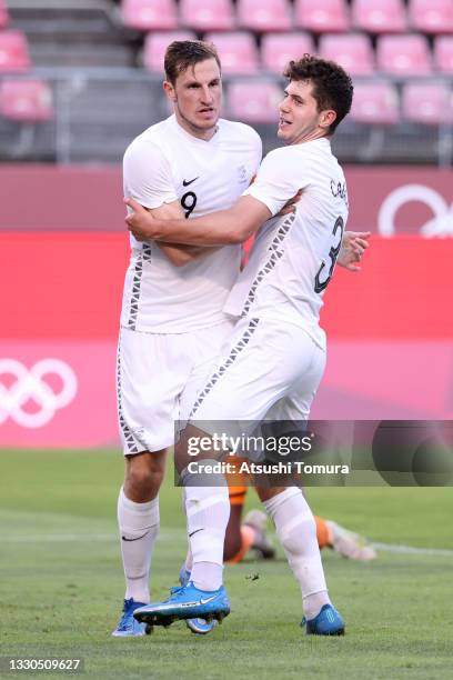 Chris Wood of Team New Zealand celebrates with teammate Liberato Cacace after scoring their side's second goal during the Men's First Round Group B...