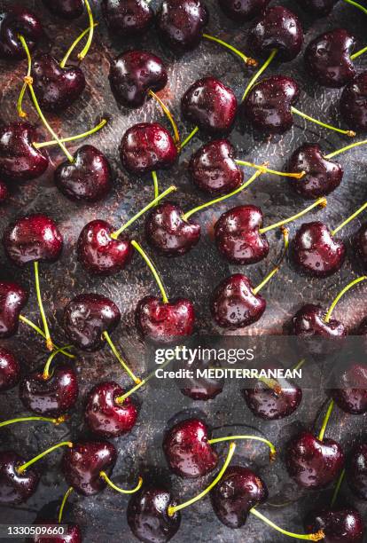 frutas de cereza frescas con gotas de agua de rocío sobre fondo de mal humor gris oscuro - estudio de mercado fotografías e imágenes de stock